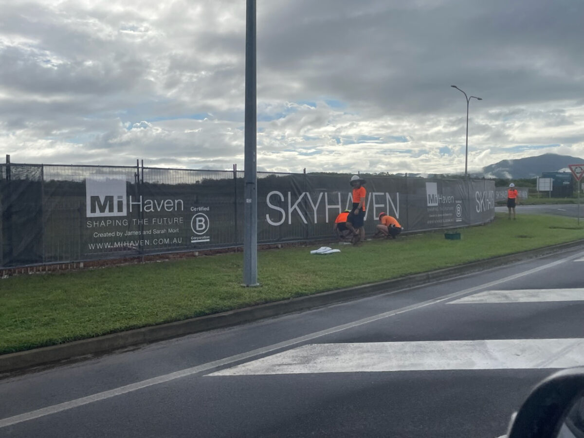 Staff installing fence mesh signage